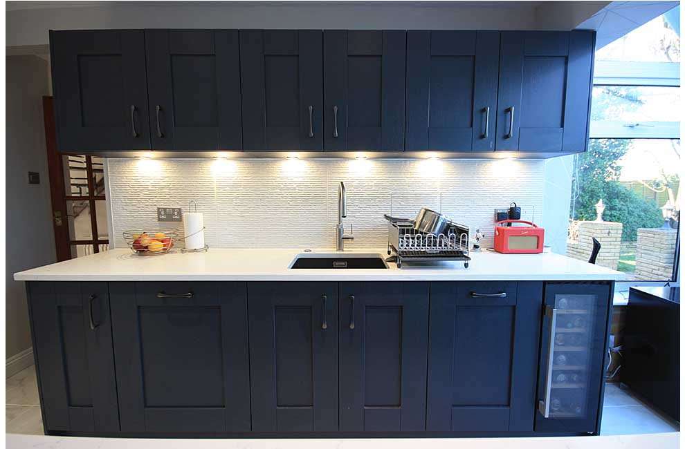 Wine cooler built into navy shaker cabinetry